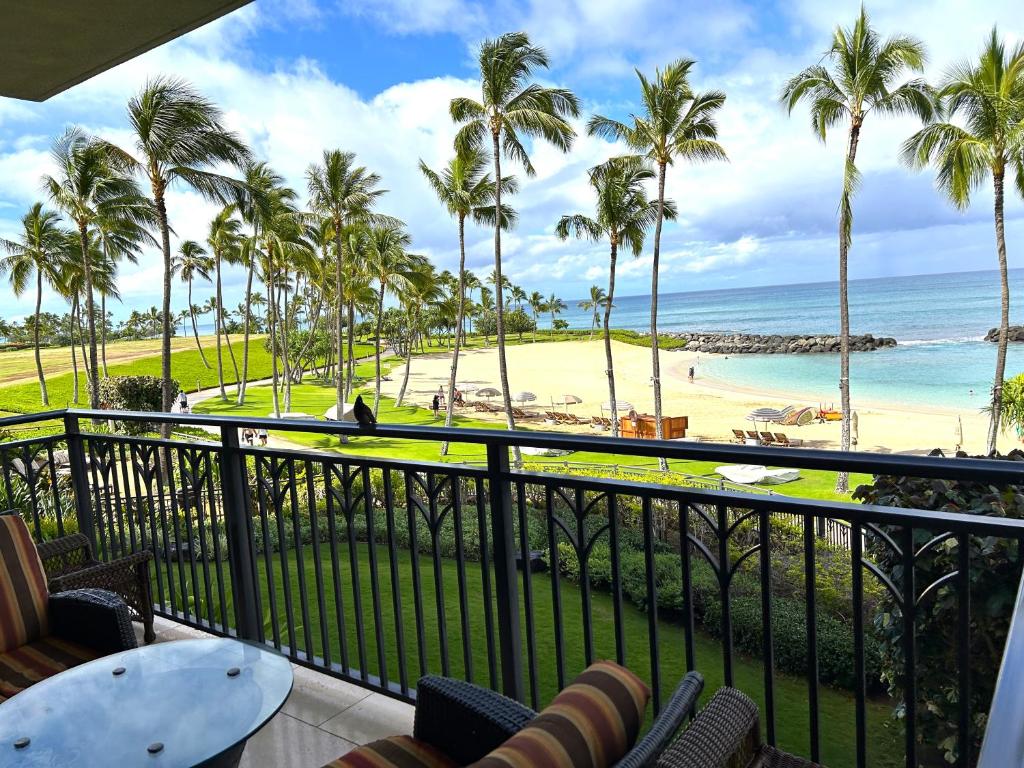 a balcony with a view of the beach and palm trees at Ko Olina Beach Villas B210 - Beach Front Luxury 2BR 2BA Condo with 1 Free Parking in Kapolei