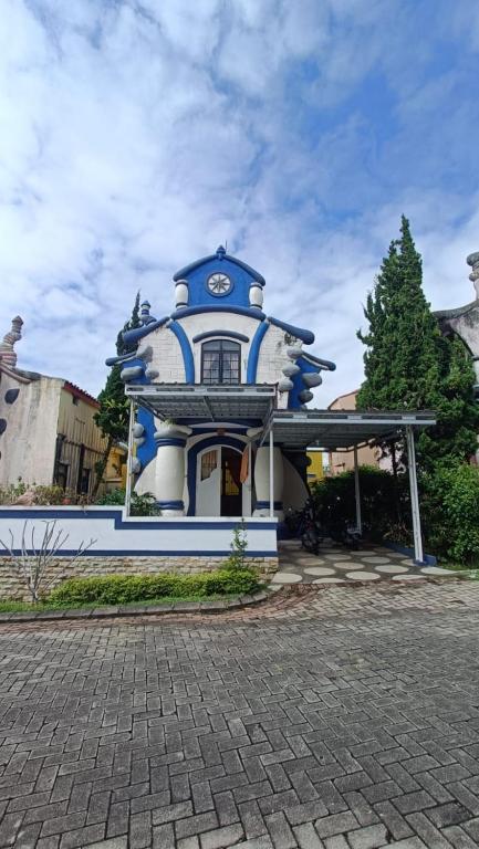 um edifício azul e branco com um relógio em Villas Dalia NA4/11 em Cianjur