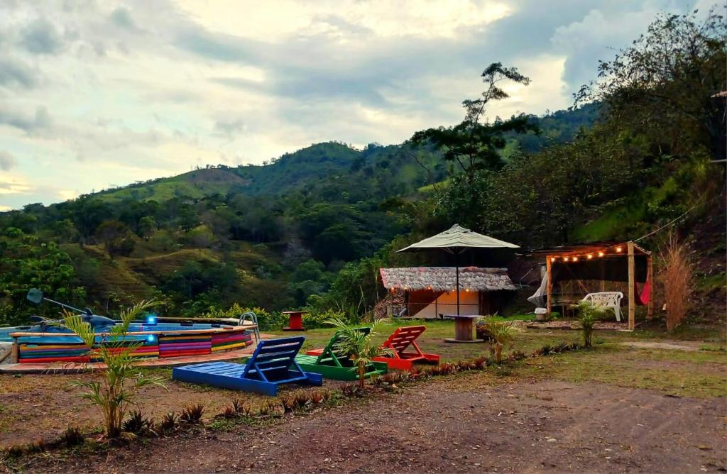 a group of colorful chairs and an umbrella at Tukus in Villeta