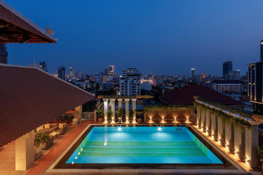 una piscina en la azotea de un edificio por la noche en Jaya Suites Hotel en Phnom Penh