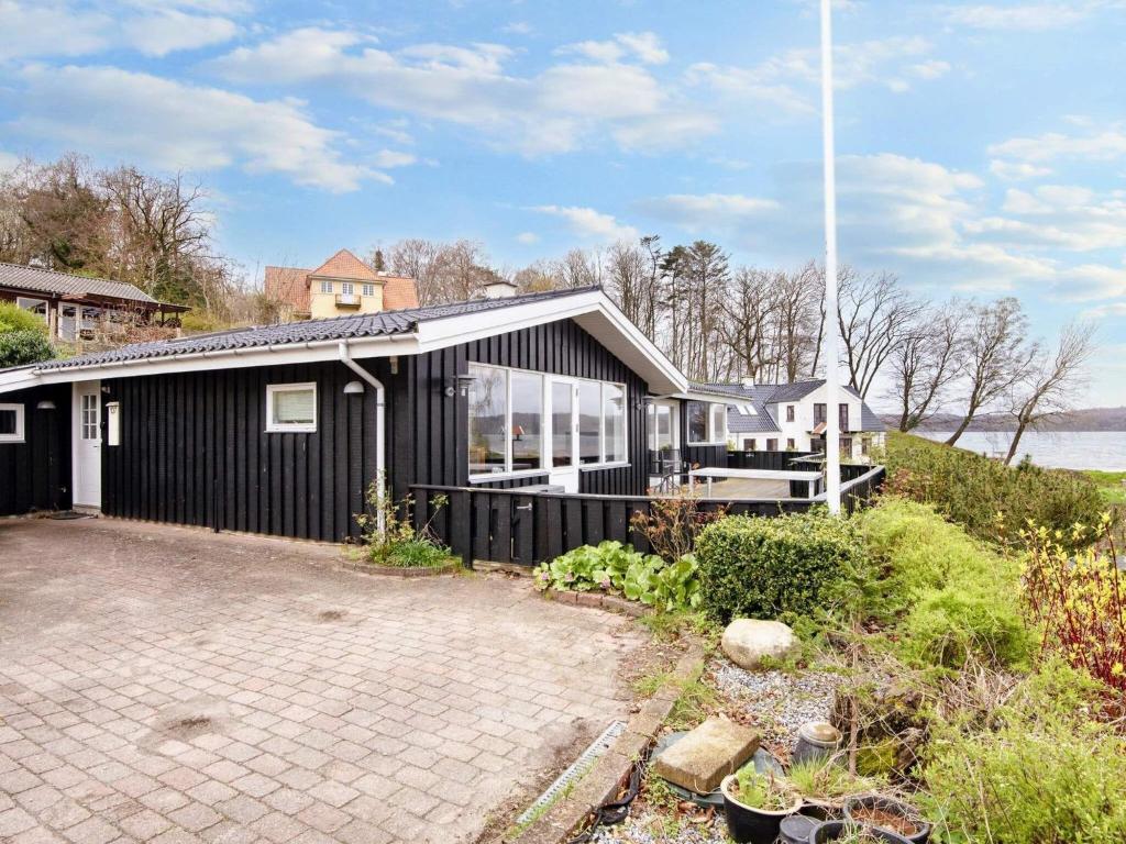 a black house with a lot of windows at 6 person holiday home in B rkop in Børkop