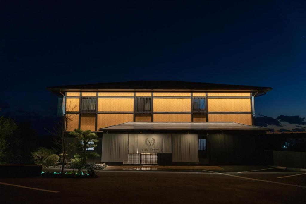 un edificio con una fachada iluminada por la noche en Villa Ryusei en Ugata