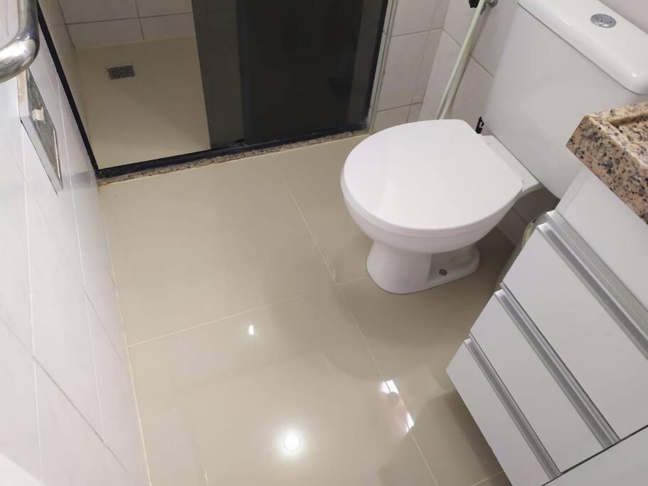 a white bathroom with a toilet and a sink at Espaço para sentir-se bem. in Fortaleza