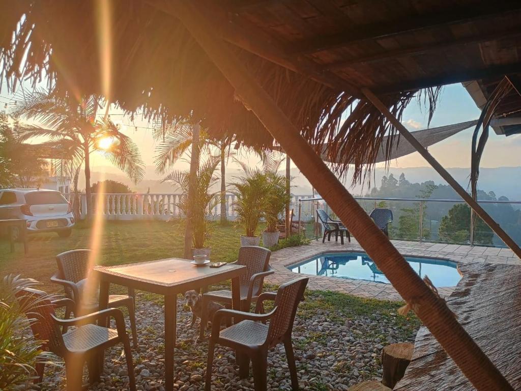 une table et des chaises installées sous une tente à côté de la piscine dans l'établissement Finca con vista al embalse y jacuzzi, à Guatapé