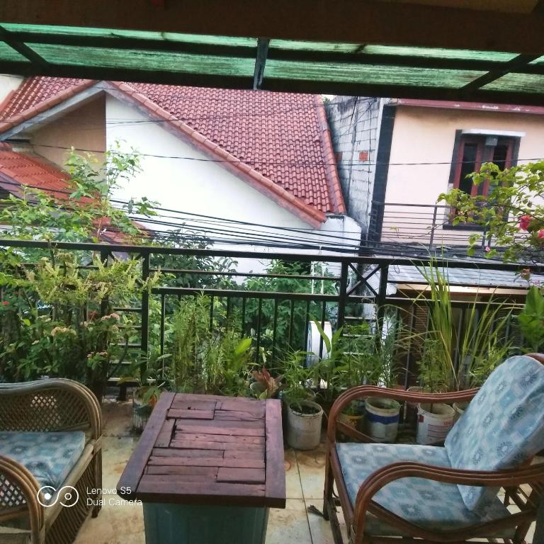 an outdoor patio with a wooden table and chairs at PM Room in Jakarta