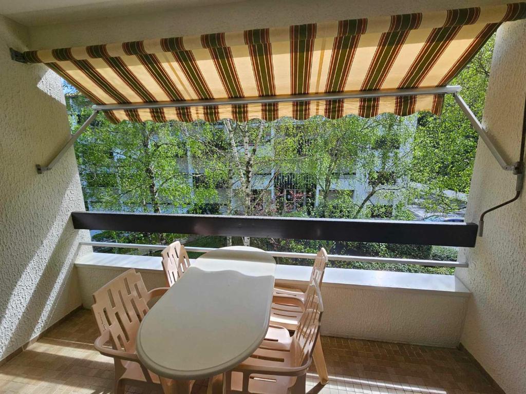 d'un balcon avec une table et des chaises devant une fenêtre. dans l'établissement Studio Cozy à 3 min de la Plage avec Parking et Balcon - FR-1-550-74, à Saint-Georges-de-Didonne