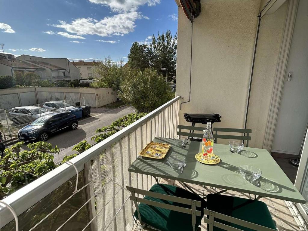 - un balcon avec une table et une voiture dans une rue dans l'établissement Appartement T2 cabine climatisé avec garage et terrasse au Grau-du-Roi, 6 couchages, proche plage - FR-1-250-267, au Grau-du-Roi