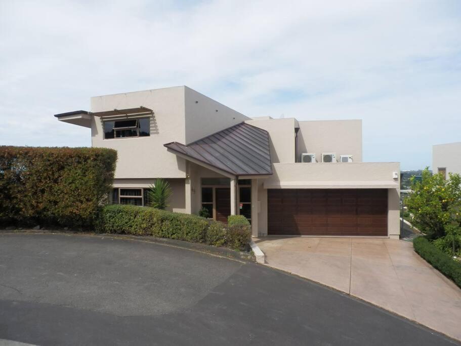 uma grande casa branca com garagem em The Rise em Napier