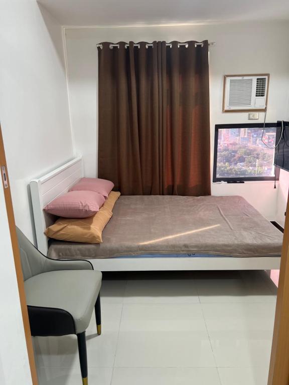 a small bedroom with a bed and a window at unit 23 greenhills, annapolis metro manila in Manila