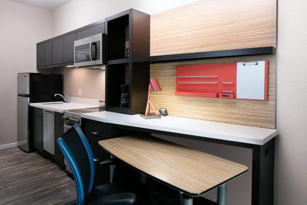 a kitchen with a counter and a table and chairs at TownePlace Suites by Marriott Kansas City Airport in Kansas City