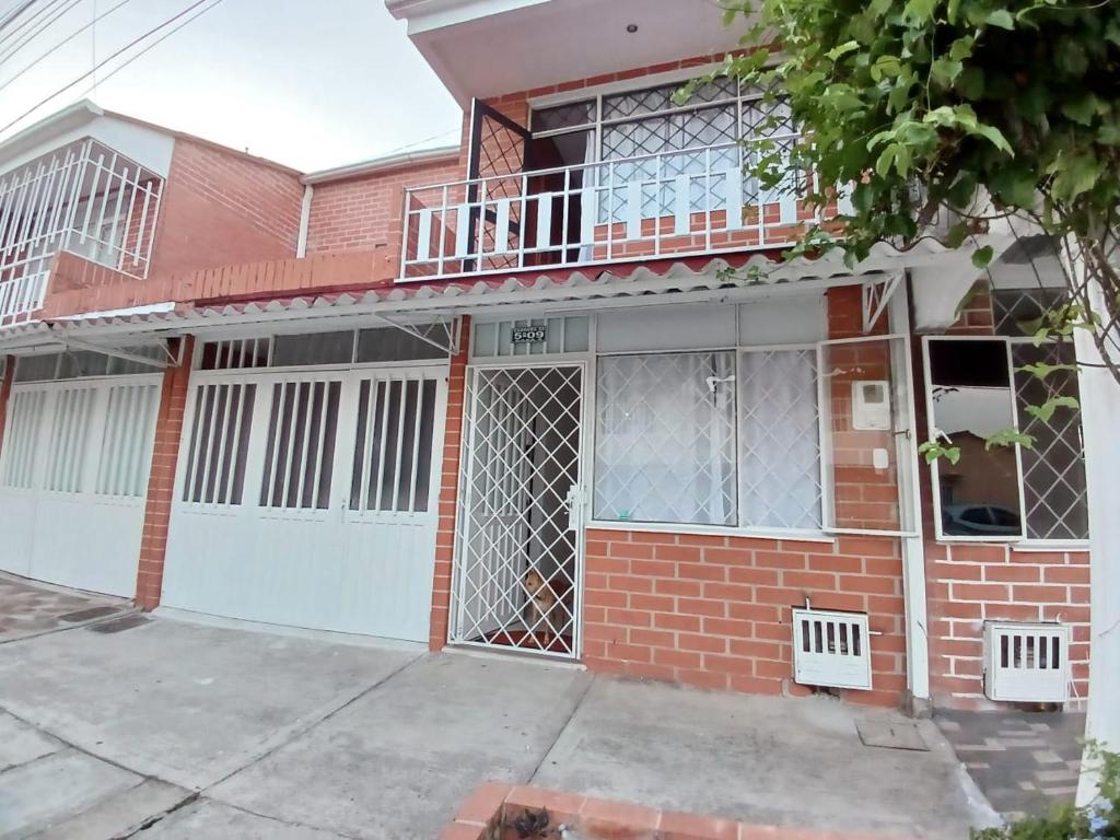 uma casa de tijolos vermelhos com uma garagem branca em Moderna casa Villavicencio em Villavicencio