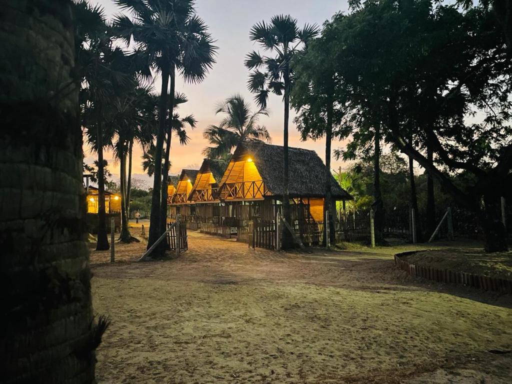 een gebouw met palmbomen in een park bij Borassus Nature Huts in Jaffna