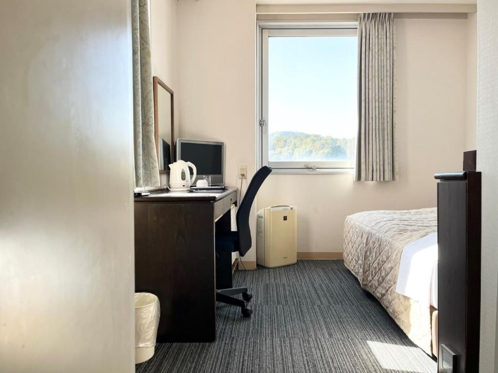 Postel nebo postele na pokoji v ubytování Nakamura Daiichi Hotel