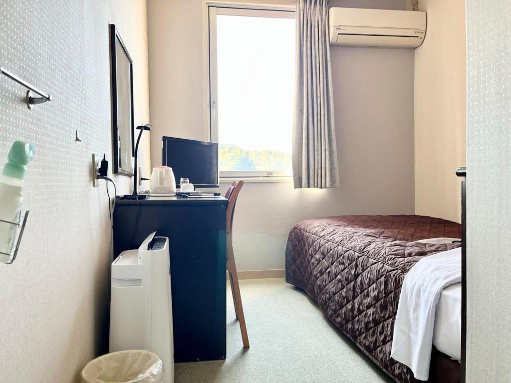 Postel nebo postele na pokoji v ubytování Nakamura Daiichi Hotel