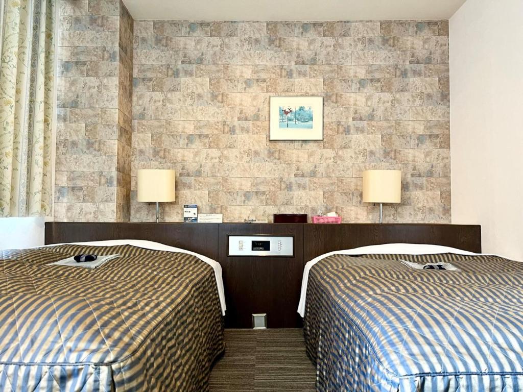 Postel nebo postele na pokoji v ubytování Nakamura Daiichi Hotel