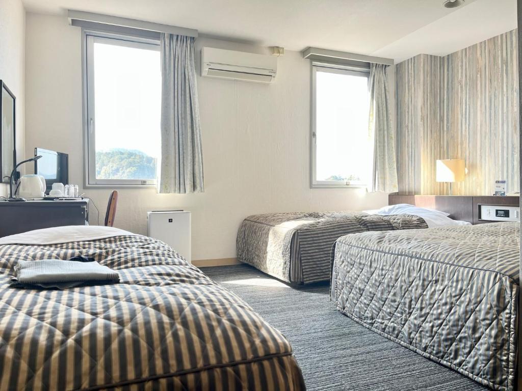 Postel nebo postele na pokoji v ubytování Nakamura Daiichi Hotel