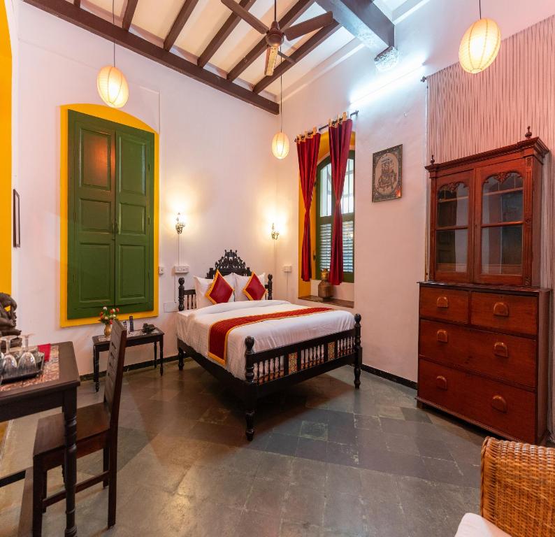 a bedroom with a bed and a green door at Luigi Villa in Puducherry