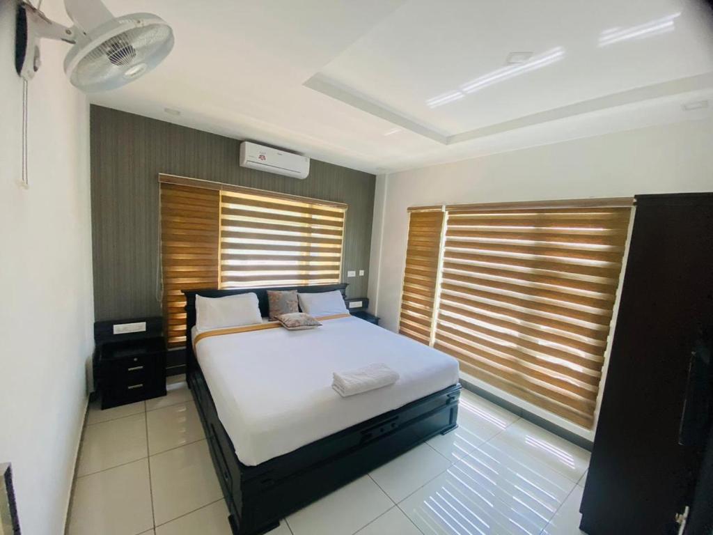 ein Schlafzimmer mit einem Bett in einem Zimmer mit Fenstern in der Unterkunft Natural king Queen residency in Sultan Bathery