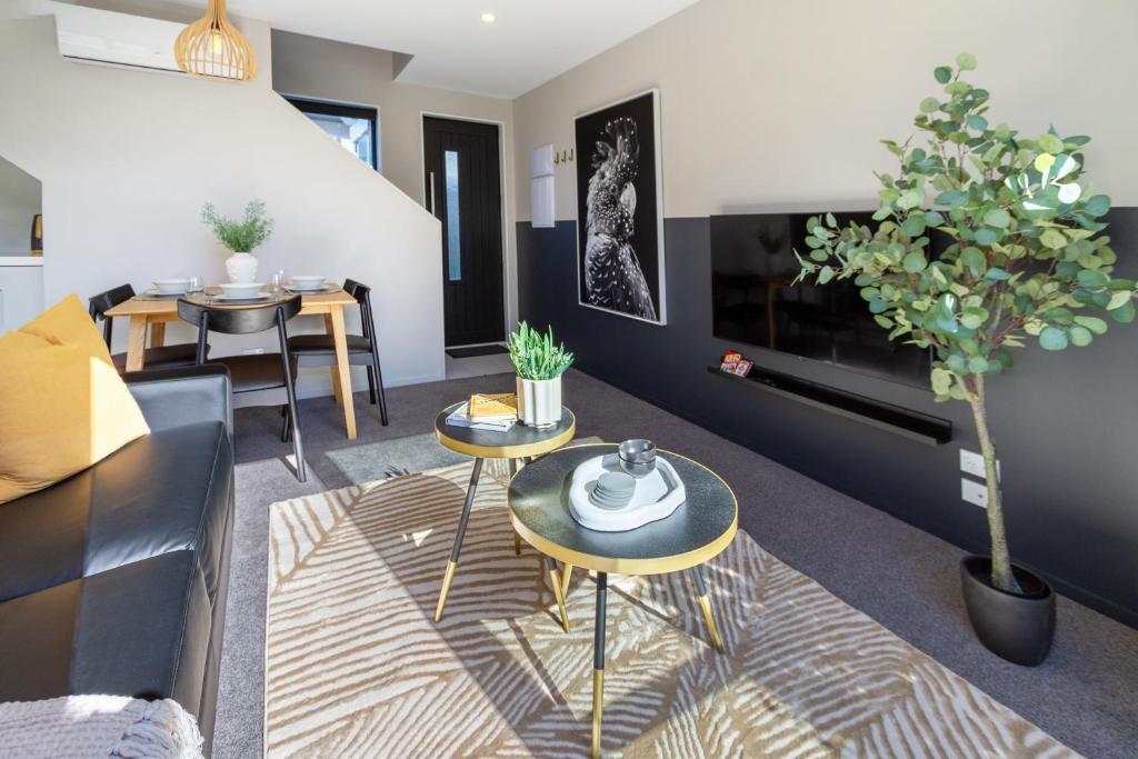 sala de estar con 2 mesas y sofá en Luxury Without Limits in CBD Christchurch, en Christchurch