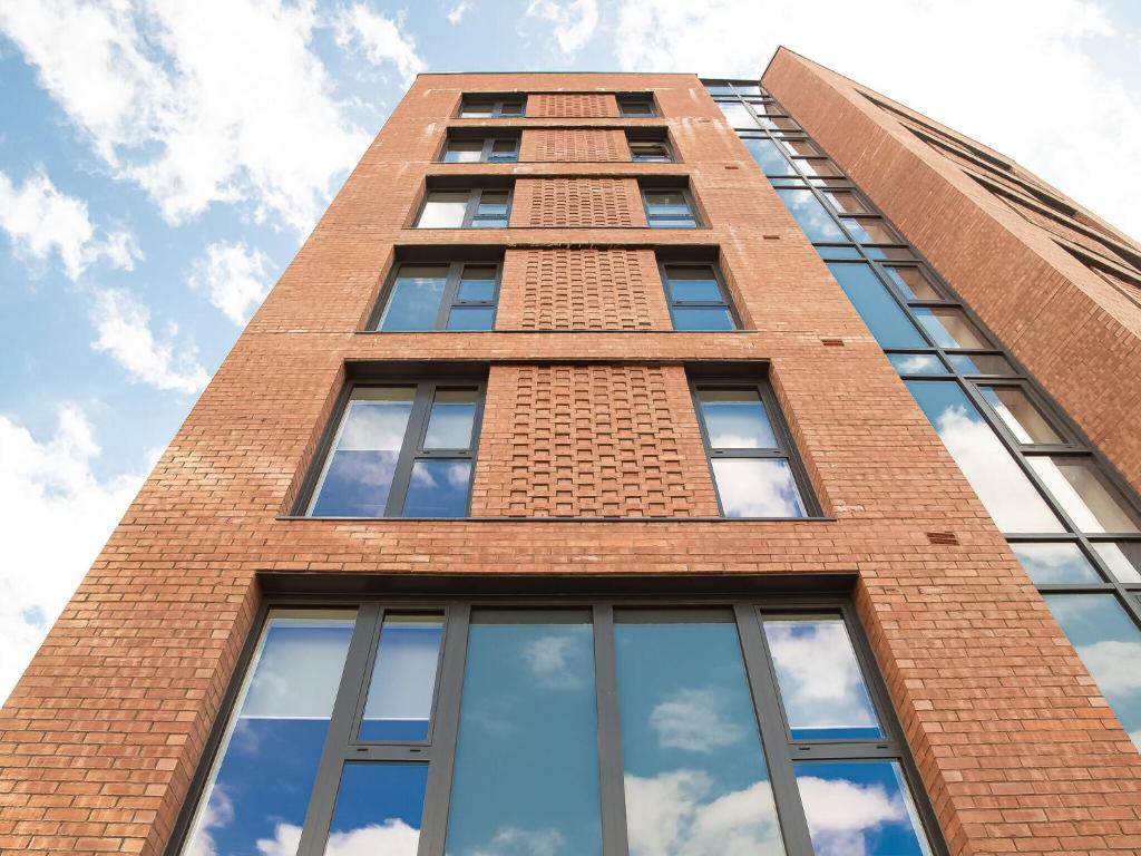 a tall brick building with windows on top of it at Kelham Gate Central Apartments Near Peaks Crucible Utilita Arena in Sheffield