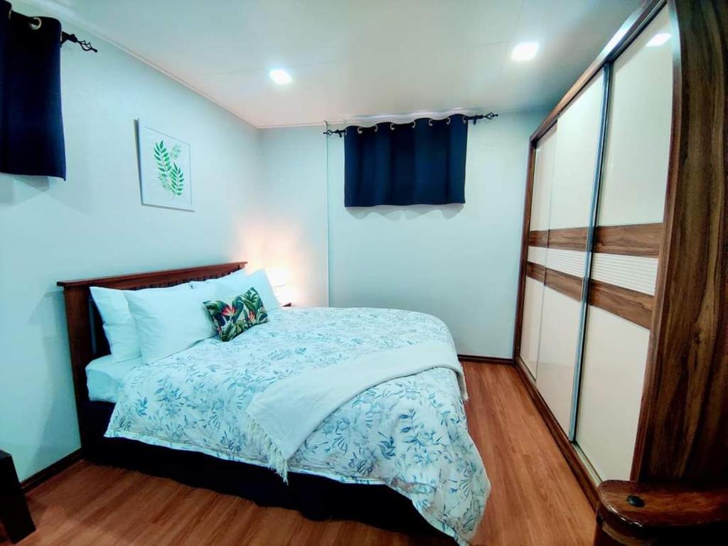 a bedroom with a bed with blue walls at Studio at Berry Road in Suva