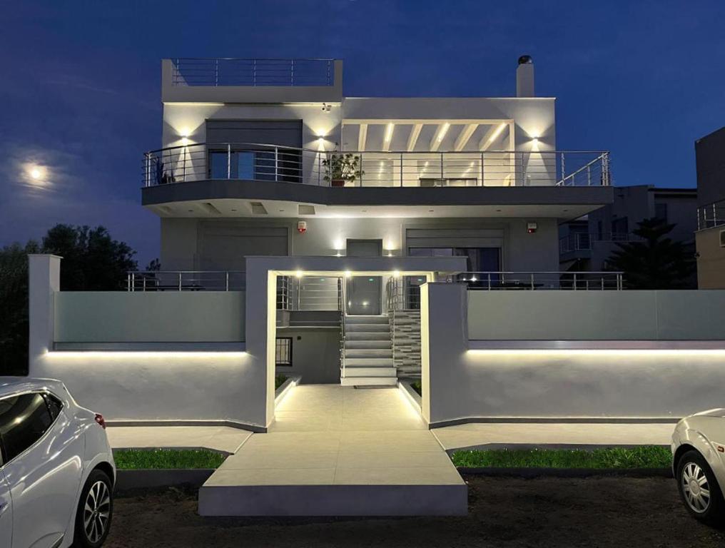 a white house with a car parked in front of it at BlueLine apartment 3 in Loutraki