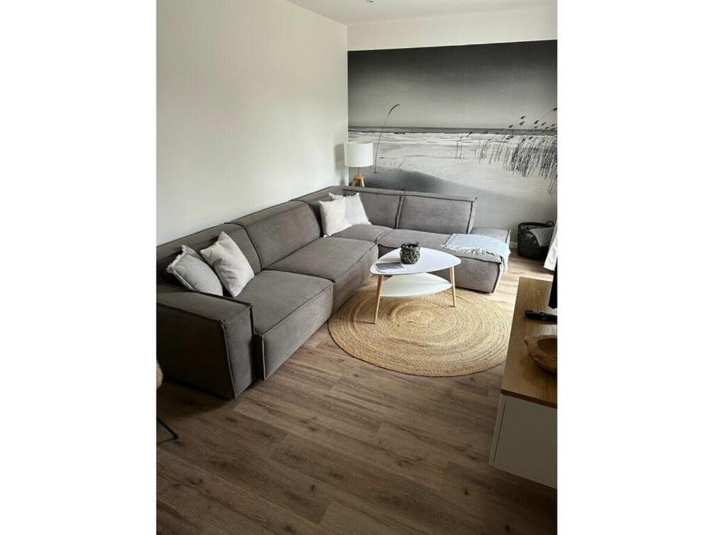 una sala de estar con un sofá y una mesa en Friesenstuv Modern retreat, en Tönning