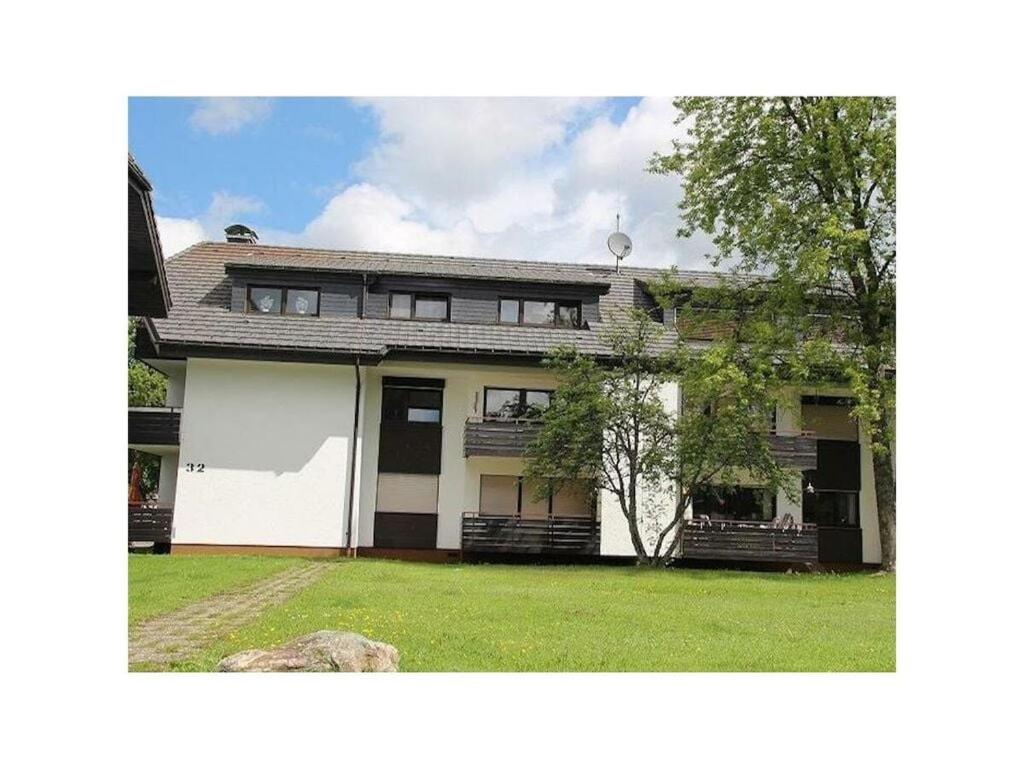 a large white house with a grass yard at Yvonne Modern retreat in Titisee-Neustadt
