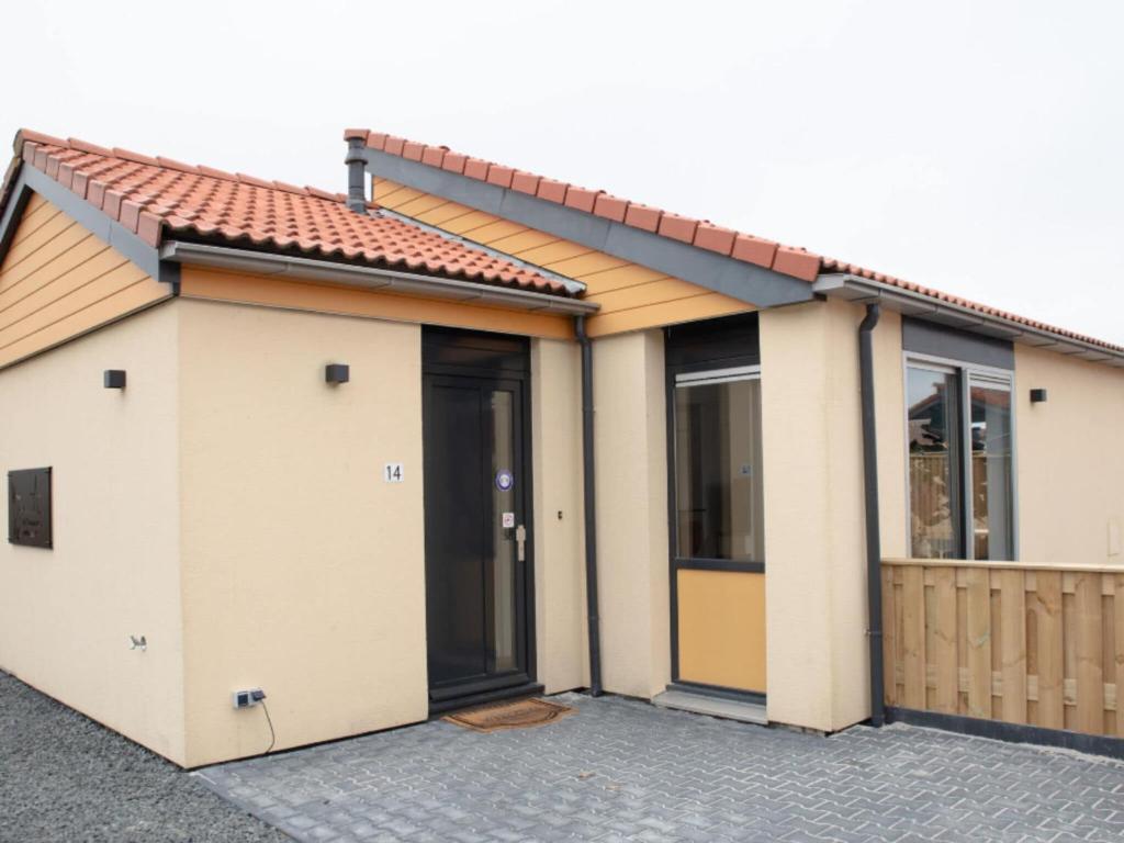 una casa con due porte e una recinzione di Wellness Bungalow with whirlpool and sauna a Zevenhuizen