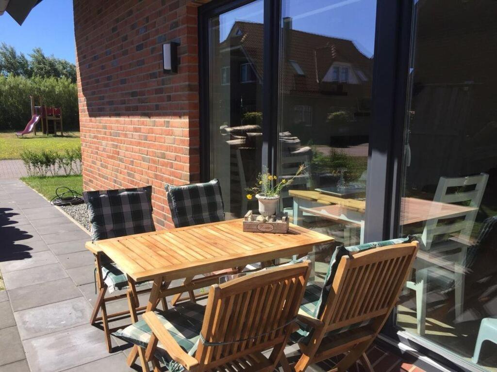 een houten tafel en stoelen op een patio bij Ostbake Modern retreat in Wangerooge