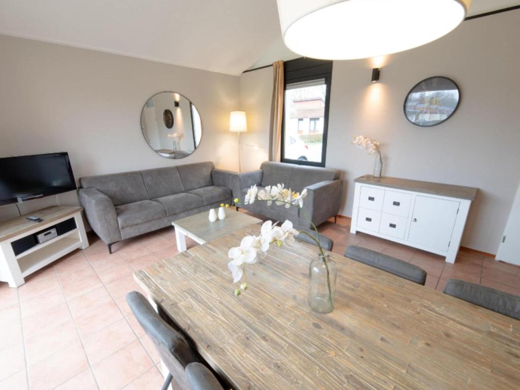 a living room with a table and a couch at Premium bungalow 6 persons in Zevenhuizen