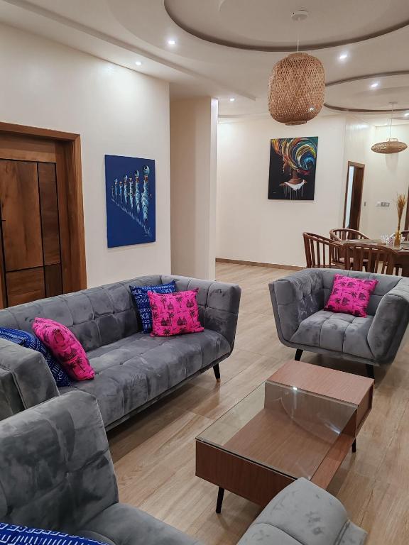 ein Wohnzimmer mit einem Sofa und einem Tisch in der Unterkunft Le Leo Lodge in Lomé