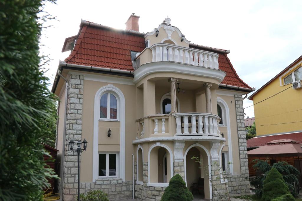 ein großes Haus mit einem Turm in der Unterkunft Aradi Vendégház in Miskolctapolca