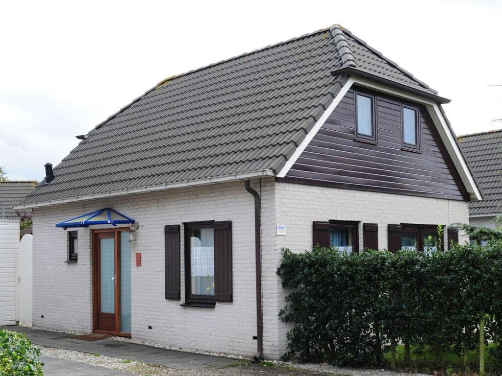 a white house with a black roof at Huijsmansverhuur Type B de Luxe Grevelingen 15 in Ouddorp