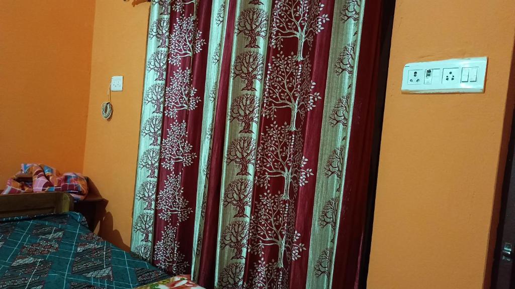 een slaapkamer met een rood gordijn naast een bed bij Shail guest house in Ayodhya