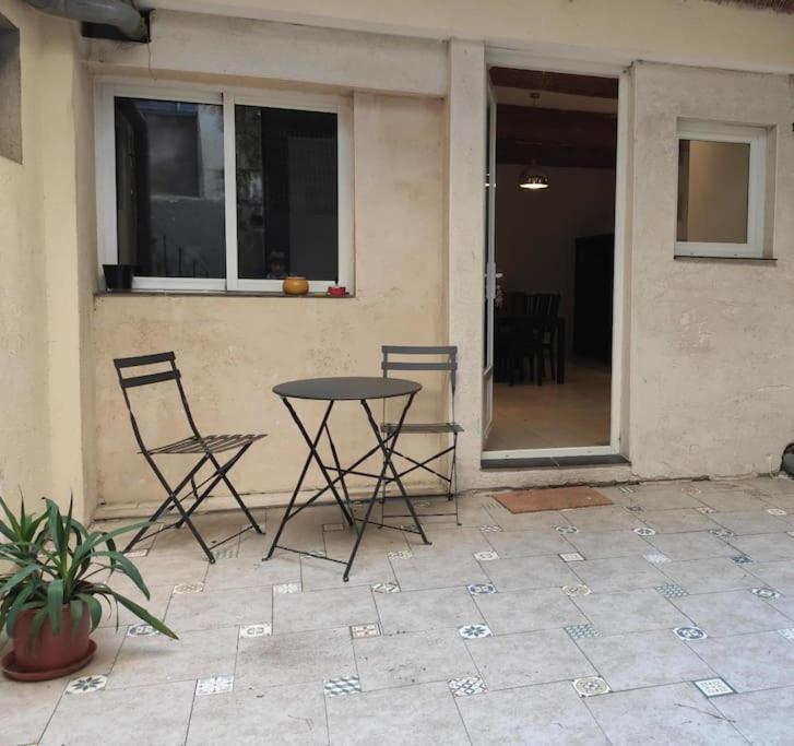 2 Stühle und ein Tisch vor einem Haus in der Unterkunft Très grand et bel appartement in Nîmes
