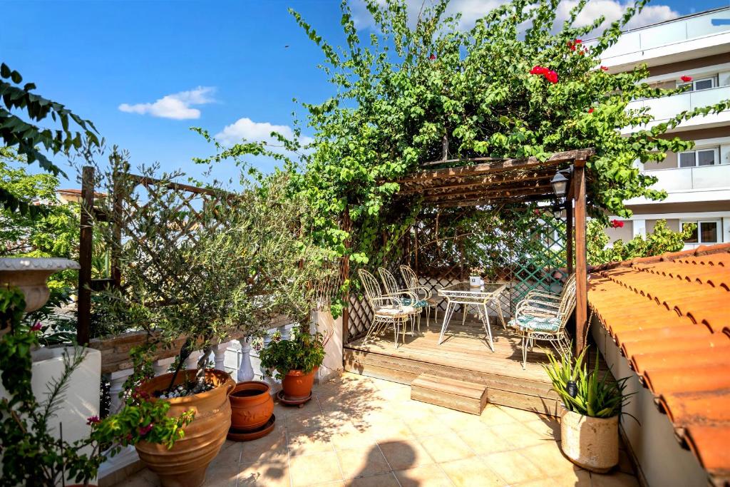 a patio with a table and chairs and plants at Apeiron Acropolis Suites in Athens
