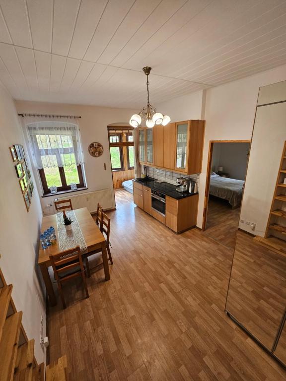 a kitchen and living room with a table and chairs at Apartament Słowackiego in Karpacz