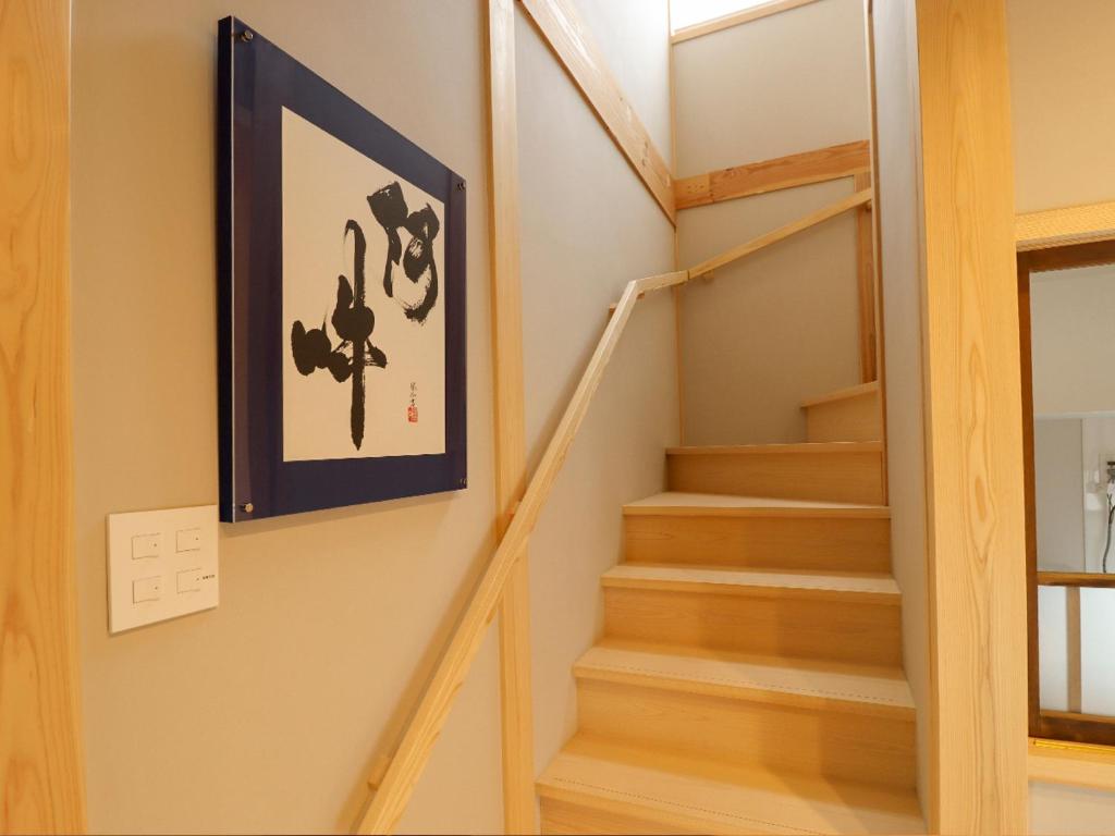 a staircase in a house with a picture on the wall at A-UN lNN 会津若松 人気観光地へ車で10分 in Aizuwakamatsu
