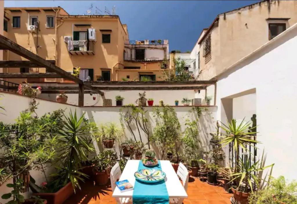 a patio with a table and some plants and a building at In the Heart Of The Kalsa! Two Apartemts Free Park, No ZTL ! Ideal for remote work! in Palermo