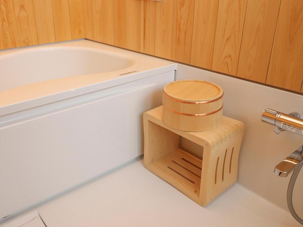 a bathroom with a toilet and a tub with a wooden stool at A-UN lNN 会津若松 人気観光地へ車で10分 in Aizuwakamatsu