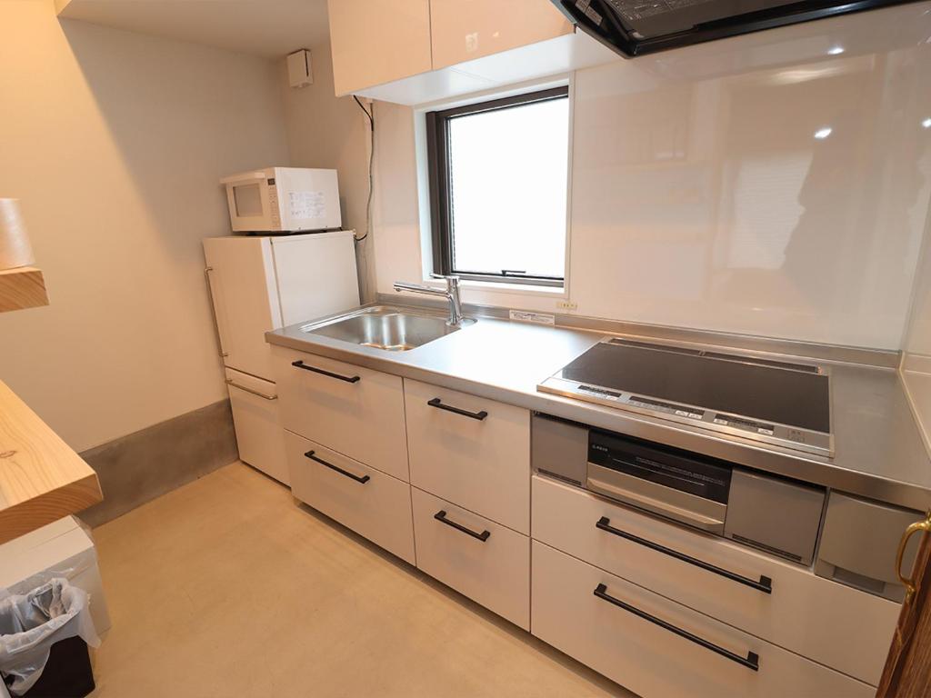a kitchen with a sink and a refrigerator at A-UN lNN 会津若松 人気観光地へ車で10分 in Aizuwakamatsu