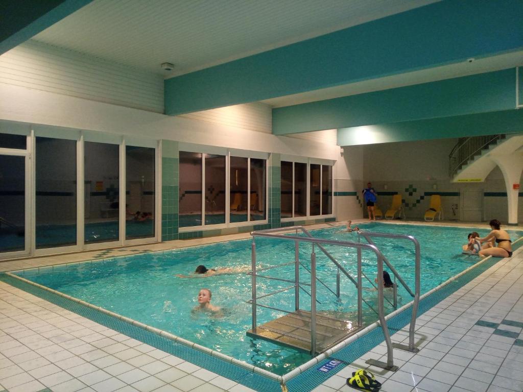 a large swimming pool with people in the water at Appartement mit Hallenbad in Sankt Martin bei Lofer