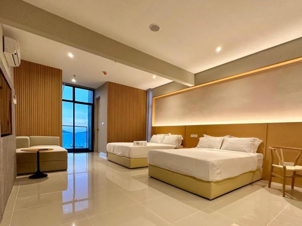 a hotel room with two beds and a window at The Shore by MD Staycation in Kota Kinabalu