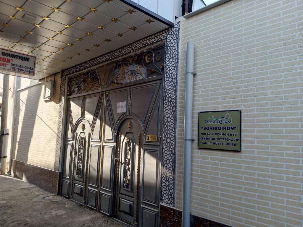Una puerta a un edificio con un cartel. en Hotel Sohibqiron Boutique en Bukhara