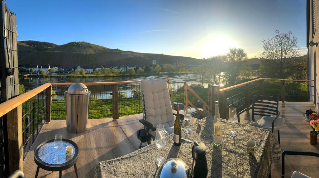 d'un balcon avec une table et une vue sur la rivière. dans l'établissement Das besondere Moselhaus-Mosel ultranah, à Kinheim