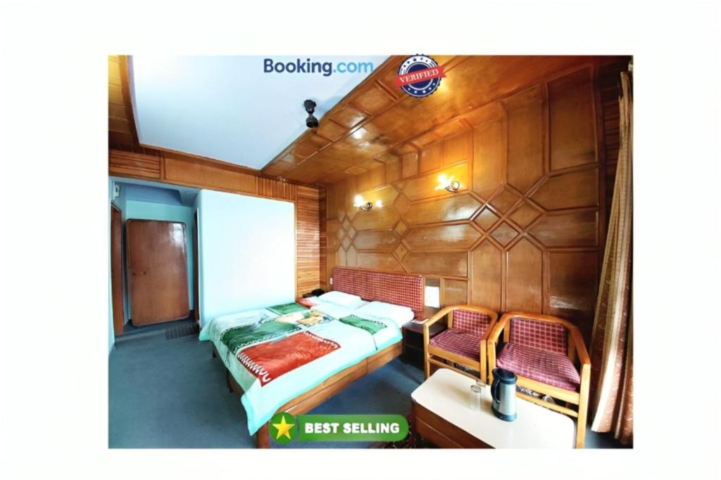 une chambre avec un lit et deux chaises dans un bateau dans l'établissement Hotel Radha Continental Nainital Near Mall Road - Hygiene & Spacious Room - Prime Location - Best Selling, à Nainital