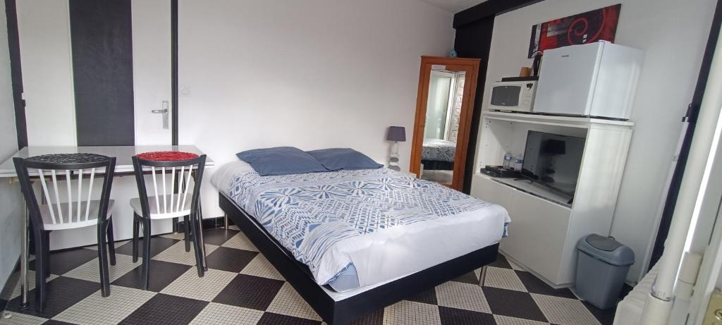 1 dormitorio con 1 cama y 1 mesa con microondas en Chambre privative à st remy en mauges, en La Chaussaire