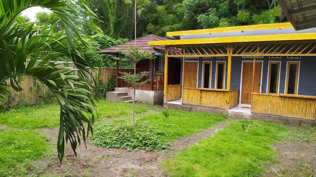 ein blaues Haus mit Holztüren im Hof in der Unterkunft de Travelodge Homestay 