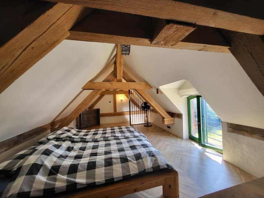 a bedroom with a checkered bed in a attic at Domek pod Klonem in Lubliniec